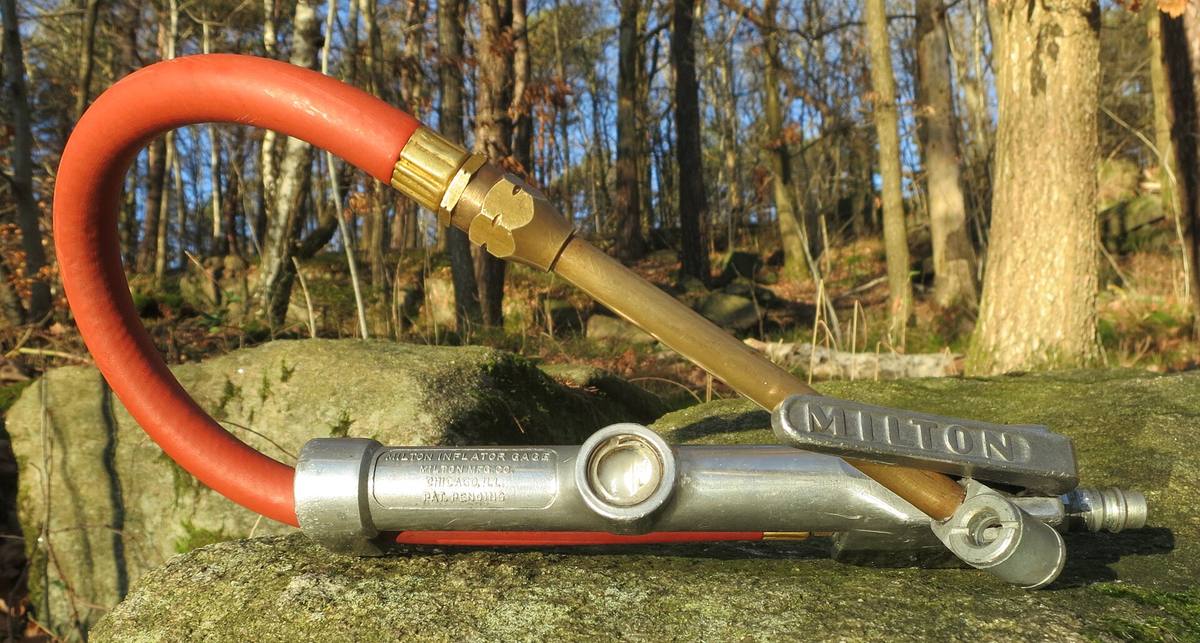 Měřič tlaku a koncovka pro huštění pneumatik