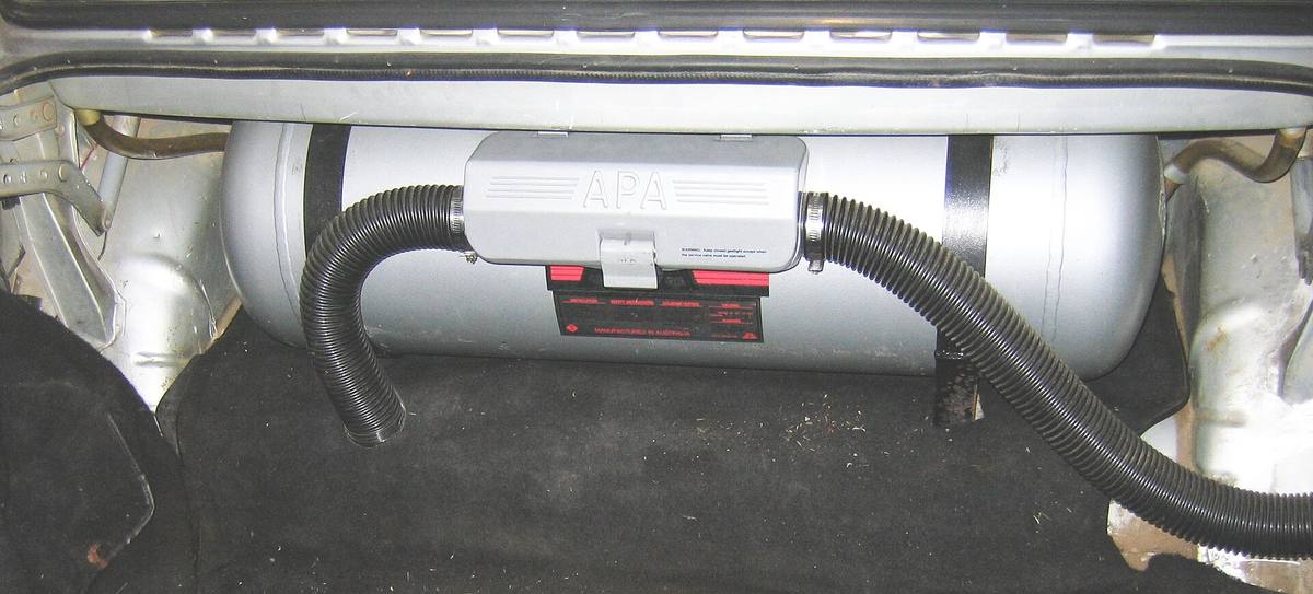 Válcová nádrž LPG upevněná pásy v zavazadlovém prostoru sedanu